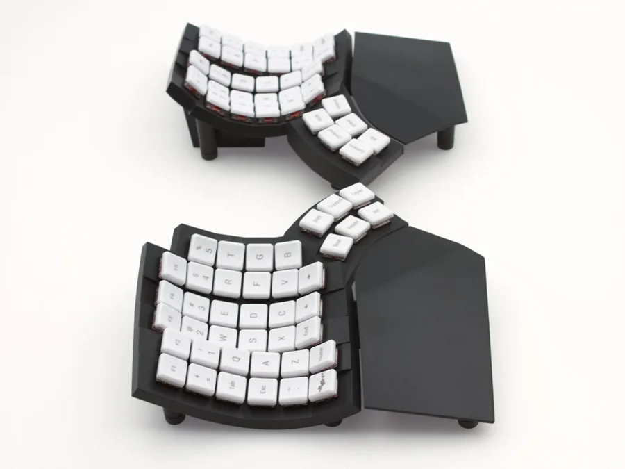MoErgo Glove80 split keyboard with contoured key wells and white low-profile keycaps.