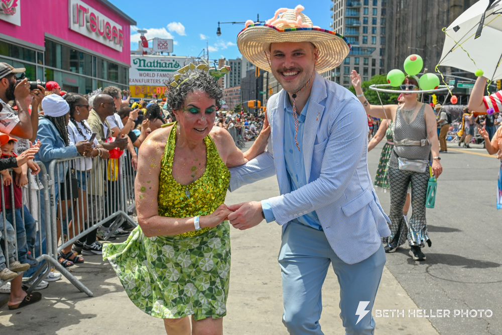 Ben dancing with a woman in a green costume at the Mermaid Parade.